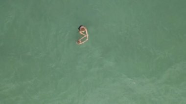 Havadan yavaş çekim. Mavi denizde eğlenen bir anne-oğul manzarası.