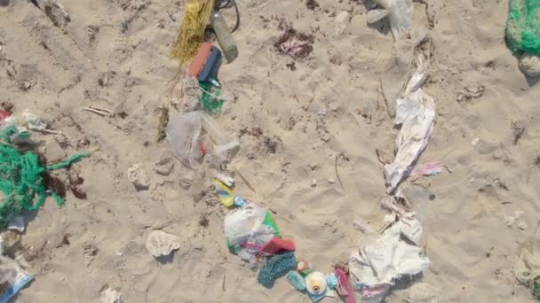 Foto aérea del cartel SOS hecho de basura en una playa. Concepto de desastre ecológico. Concepto de contaminación plástica — Vídeos de Stock