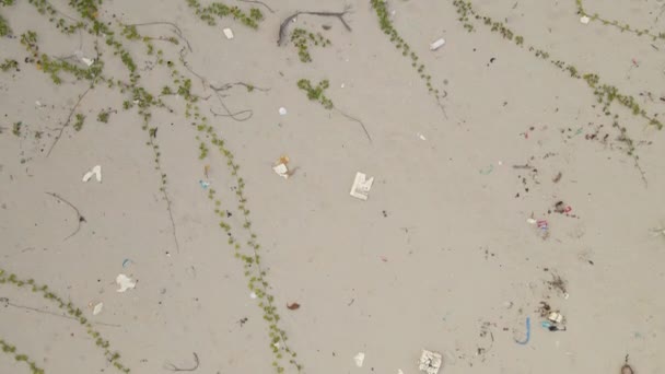 Vue aérienne du haut vers le bas sur une belle plage de sable recouverte de poubelles, principalement en plastique. En raison des restrictions COVID-19 les stations sont fermées, donc personne ne nettoie les plages dans les pays tropicaux — Video