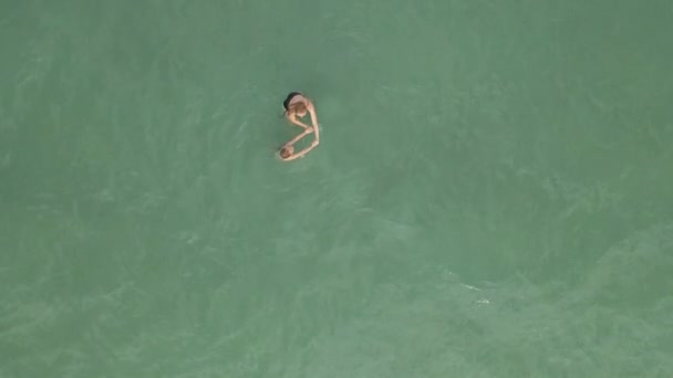 Luftaufnahme in Zeitlupe. Blick von oben auf Mutter und Sohn, die Spaß im blauen Meer haben — Stockvideo