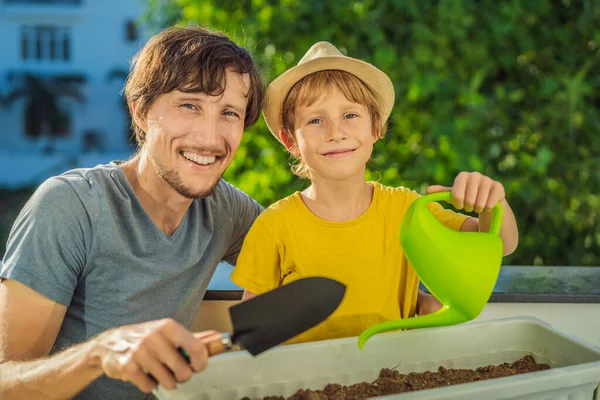 O pai e o filho estão a fazer jardinagem na varanda. Desenvolvimento natural para crianças — Fotografia de Stock