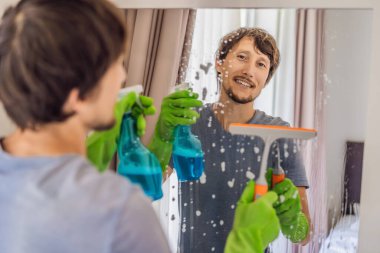 Otelde ayna temizleyen genç adam.