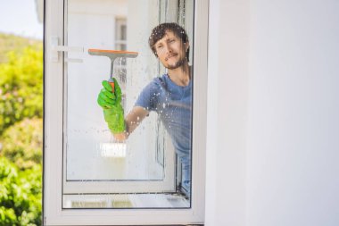 Pencereyi temizleyen genç bir adam.