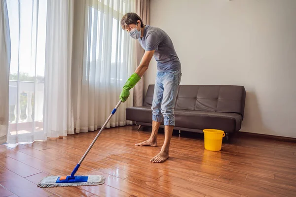 Joven con piso de limpieza de fregona en casa durante coronavirus COVID 19 — Foto de Stock