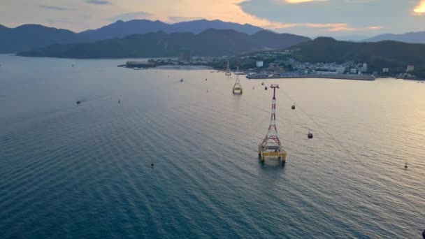 Zeitlupenaufnahme einer Seilbahn über einem Meer. Schöne Sonnenuntergangsaufnahme der Stadt Nha Trang, Vietnam — Stockvideo