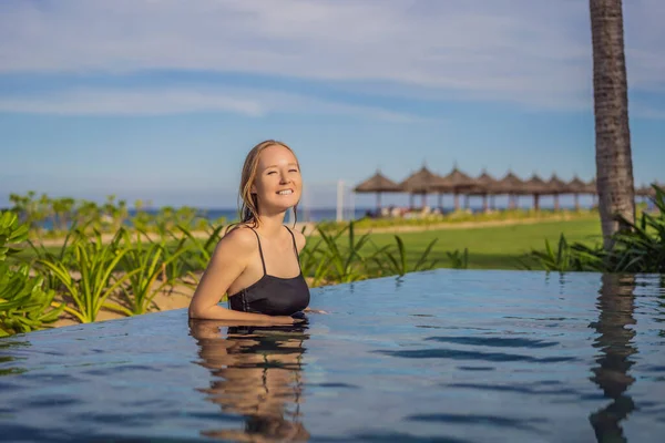 Donna rilassante in piscina a sfioro guardando la vista — Foto Stock