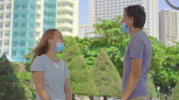 두 젊은 남녀가 의료용 마스크를 잘못 착용하고 대화를 나누고 있습니다. 그들의 가면은 코를 가려 주지 않는다. 안면 마스크를 잘못 쓰는 방법 — 비디오