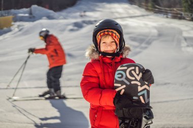 Küçük şirin çocuk snowboard yapmaya hazır. Kışın çocuklar için etkinlikler. Çocuklar kış sporu. Yaşam biçimi