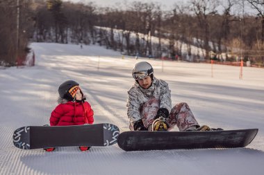 Babası oğluna snowboard öğretiyor. Kışın çocuklar için etkinlikler. Çocuklar kış sporu. Yaşam biçimi