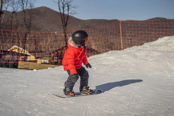 Kleiner netter Junge beim Snowboarden. Aktivitäten für Kinder im Winter. Kinderwintersport. Lebensstil — Stockfoto