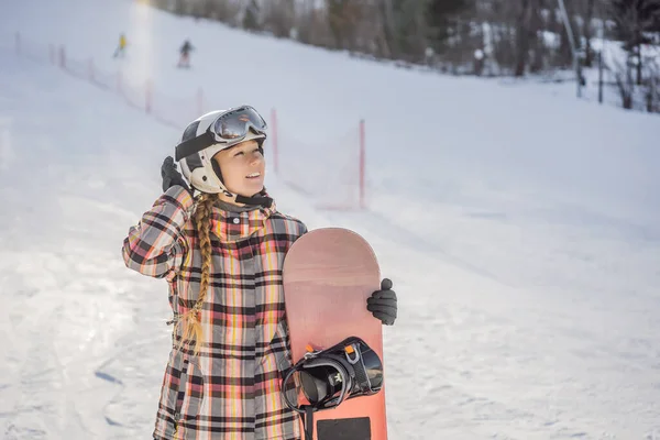 Kobieta snowboardzistka w słoneczny zimowy dzień w ośrodku narciarskim — Zdjęcie stockowe