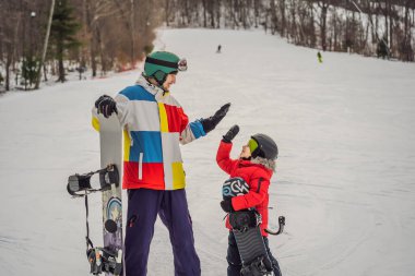 Snowboard eğitmeni bir çocuğa snowboard yapmayı öğretiyor. Kışın çocuklar için etkinlikler. Çocuklar kış sporu. Yaşam biçimi