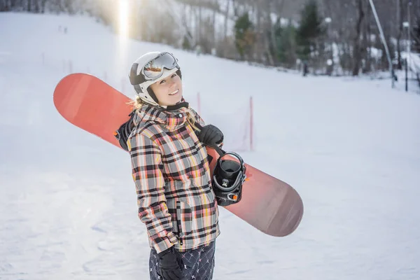 Kvinna snowboardåkare en solig vinterdag på en skidort — Stockfoto