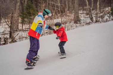 Snowboard eğitmeni bir çocuğa snowboard yapmayı öğretiyor. Kışın çocuklar için etkinlikler. Çocuklar kış sporu. Yaşam biçimi