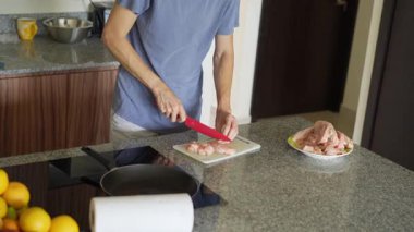 Genç bir adam mutfakta yemek pişiriyor, lezzetli bir ev yemeği hazırlamaya odaklanıyor. Sıcacık bir ortamda ev yapımı, yaratıcılık ve aşçılık keyfi.