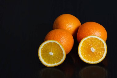 Siyah arka plan, yan görünüm üzerinde yarıya ve tüm portakal. Metin için yer.