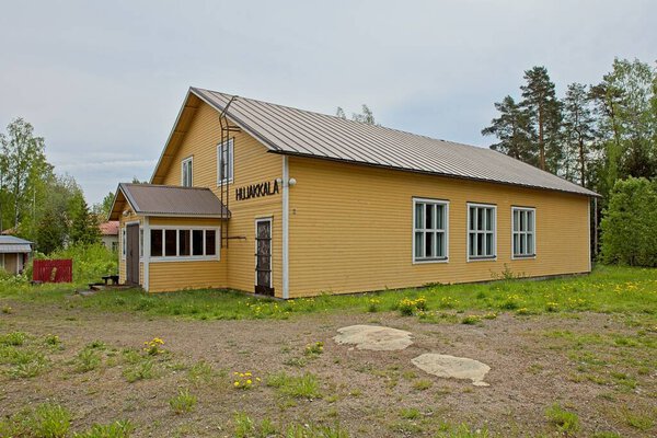 Old wooden Hujakkala community centre house in cloudy spring weather, Hujakkala, Finland.