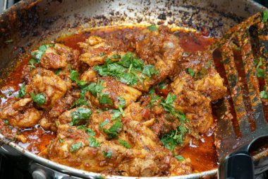 Kömürler üzerinde bir Pan içinde açık havada tava tavuk pişirme.