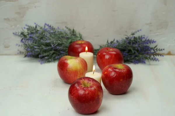 Red apples with candles and leaves. — Stock Photo, Image