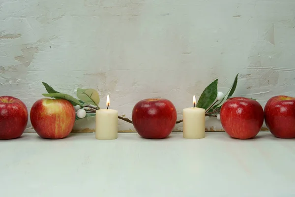 Rode appels met kaarsen en bladeren. — Stockfoto