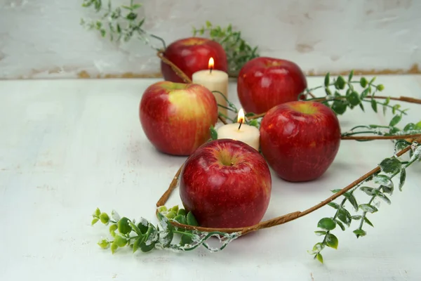 Red apples with candles and leaves. — Stock Photo, Image