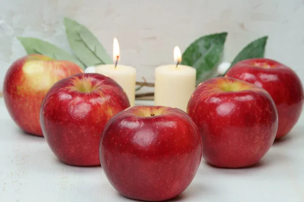 Rode appels met kaarsen en bladeren. — Stockfoto