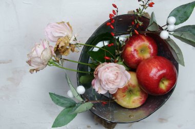 Gül çiçekli bir teneke kutuda kırmızı elmalar.