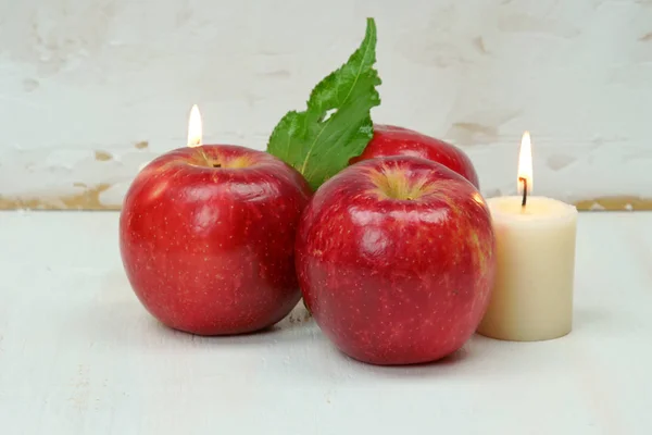 Rote Äpfel mit Kerzen und Blättern. — Stockfoto