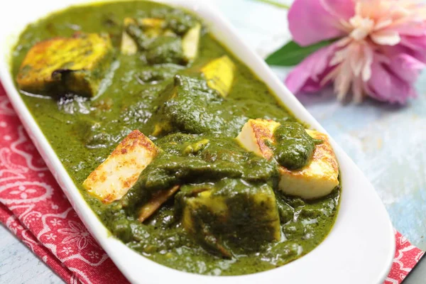 Paneer peynirinden yapılmış, yumuşak baharatlı ıspanak sosuna batırılmış bir kase Palak Paneer..