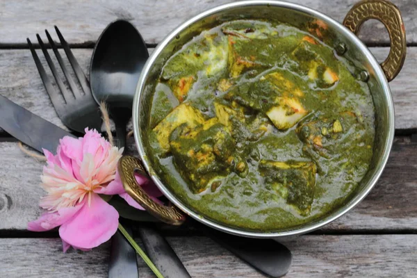 Paneer peynirinden yapılmış, yumuşak baharatlı ıspanak sosuna batırılmış bir kase Palak Paneer..