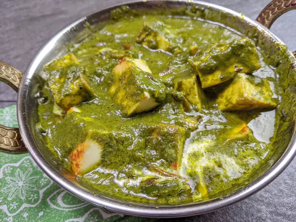 Paneer peynirinden yapılmış, yumuşak baharatlı ıspanak sosuna batırılmış bir kase Palak Paneer..