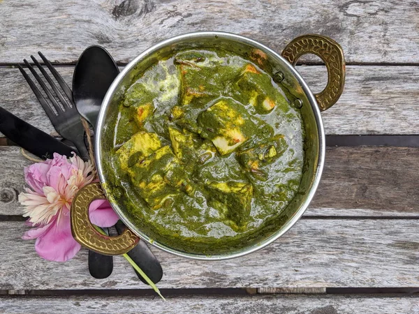 Paneer peynirinden yapılmış, yumuşak baharatlı ıspanak sosuna batırılmış bir kase Palak Paneer..