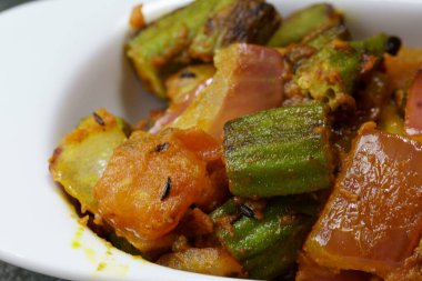 Bir tabak baharatlı ve keskin Bhindi Do Pyaza ya da Gri arkaplanlı Bhindo Masala.