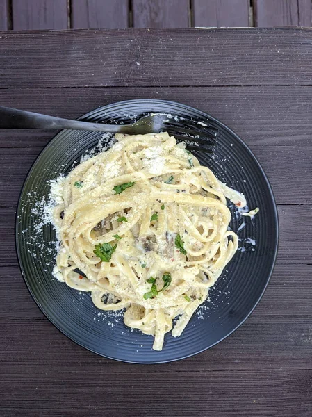 Bir tabak mantar, Alfredo Fettuccini Makarna, ahşap kahverengi arka planda..