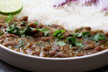 Hint kırmızı böbrek fasulyesi körisi ya da Rajma Masala ve fotokopi alanı olan pirinç tabağı..