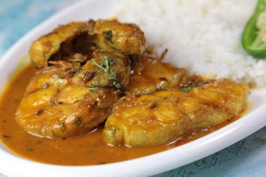 Kuzey Hint usulü, gri arka planda pilavlı körili balık tabağı..