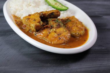 Kuzey Hint usulü, gri arka planda pilavlı körili balık tabağı..