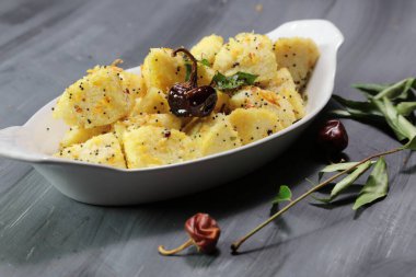 Idli Fry 'ın mayalanmış pirinçten ve Urad daal keklerinden yaptığı koyu arkaplanlı Idis..