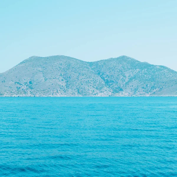 mountain landscape and sea. bright neon  blue colors. minimal and surreal. summer vacation.