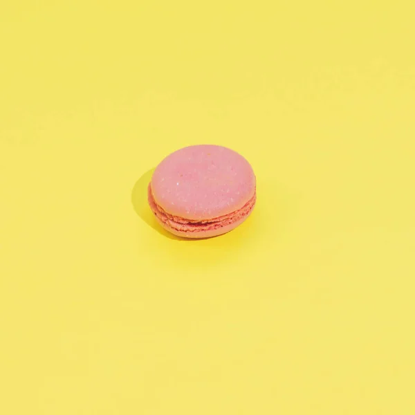 Cake macaron or macaroon on yellow background from above, colorful almond cookies, minimalism, sharp shadow