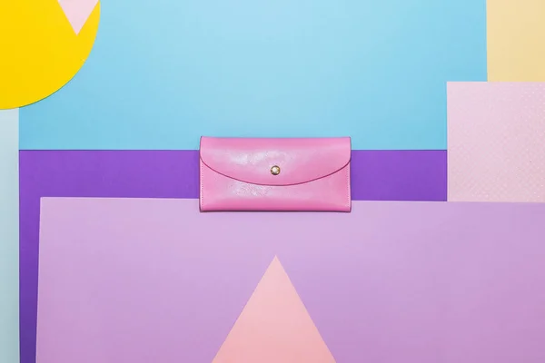 Pink leather purse or clutch on memphis style background. Geometry concept, flat lay