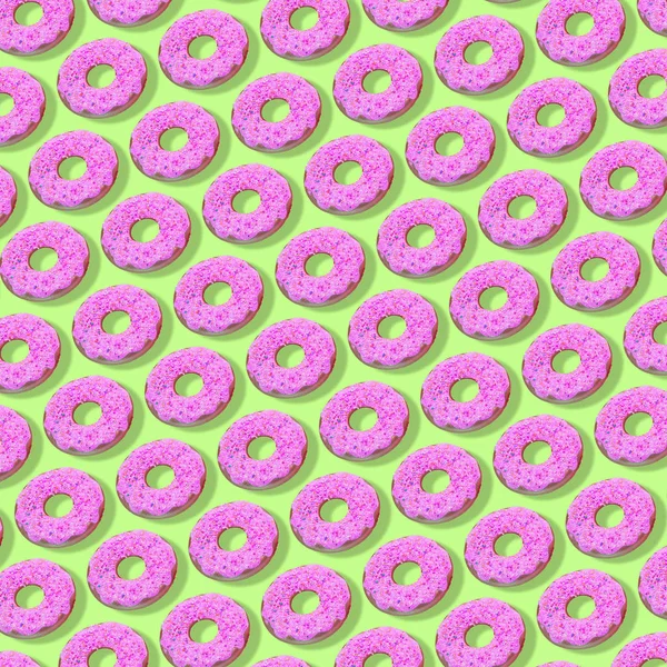 Creative art made with pink doughnuts pattern on green background