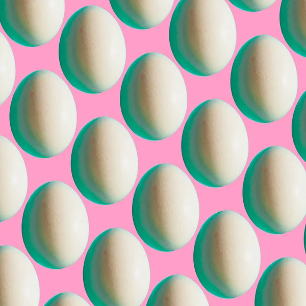 Pattern of white Easter eggs on pink bright background. Happy spring holidays concept. Minimalism.