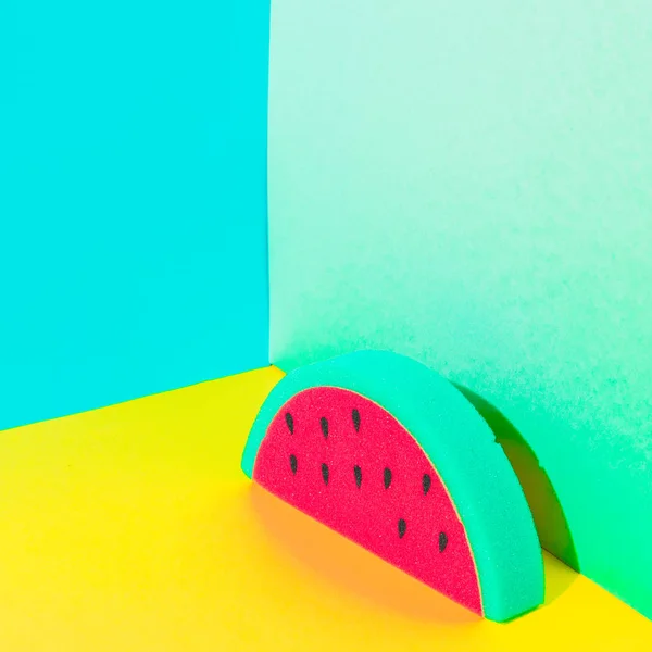 Tropical art with slice of watermelon in bright colors on bold background in the corner. Strong shadows.