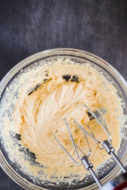 Kek ve Krep için bir kase içinde pişirme malzemeyi karıştırma. En az karanlık gıda fotoğraf tasarım konsepti. Dikey, düz yatıyordu