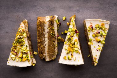 Çiğ vegan fıstıklı havuçlu kek yukarıdan kaju krem katmanlarda beton tablo ile. Karanlık gıda fotoğraf tasarım konsepti.