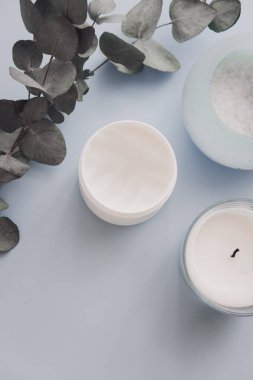 Kadın spa güzellik ürünleri üzerinde pastel mavi artalanları yukarıdan. Vücut, yüz, saç şeker tuz fırçalama, mum, okaliptüs. Minimalizm blogger kavramı