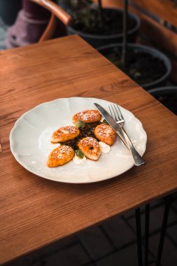 Süzme peynir krep beyaz tabakta. Ahşap masa. Gıda fotoğrafçılığı kavramı. Sıcak renkler filtre