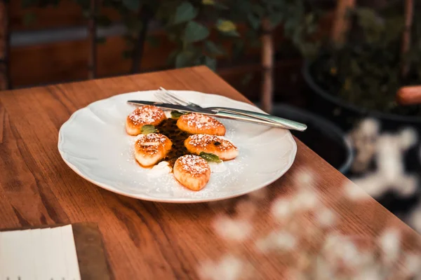 Süzme peynir krep beyaz tabakta. Ahşap masa. Gıda fotoğrafçılığı kavramı. Sıcak renkler filtre