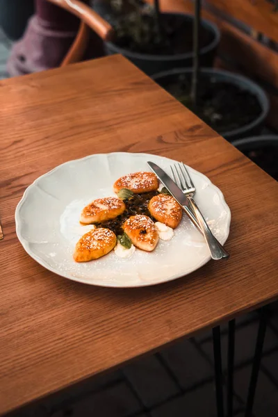 Süzme peynir krep beyaz tabakta. Ahşap masa. Gıda fotoğrafçılığı kavramı. Sıcak renkler filtre